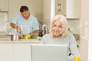 Happy mature blonde using laptop