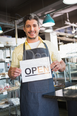 Attractive worker holding open sign