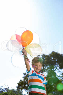 Happy little boy holding balloons