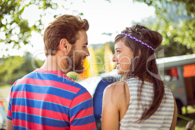 Hipster couple smiling at each other