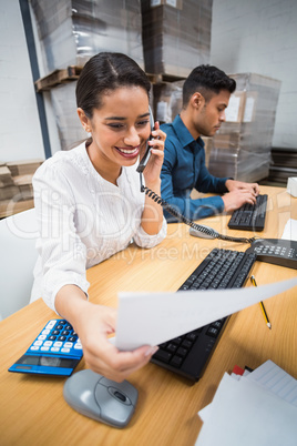 Manager making a phone call while reading a document