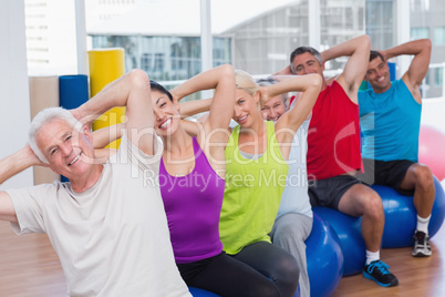 People on fitness balls exercising in gym class