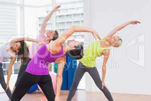Instructor and female friends doing stretching exercise