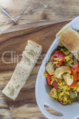 Bowl with curry flavored rice chicken and vegetables