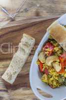 Bowl with curry flavored rice chicken and vegetables