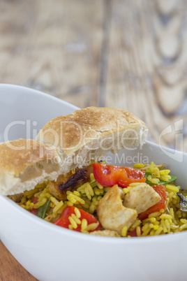 Bowl with curry flavored rice chicken and vegetables