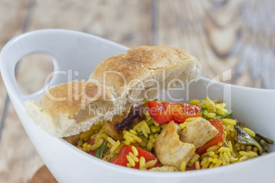 Bowl with curry flavored rice chicken and vegetables