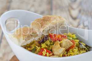 Bowl with curry flavored rice chicken and vegetables