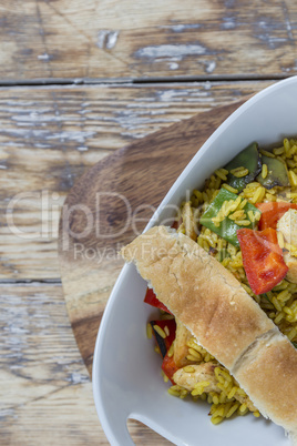 Bowl with curry flavored rice chicken and vegetables