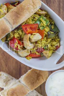 Bowl with curry flavored rice chicken and vegetables