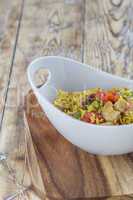 Bowl with curry flavored rice chicken and vegetables