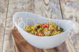 Bowl with curry flavored rice chicken and vegetables