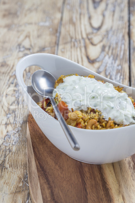 Bowl with curry flavored rice chicken and vegetables