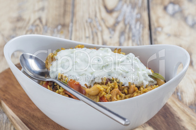 Bowl with curry flavored rice chicken and vegetables