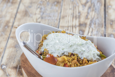 Bowl with curry flavored rice chicken and vegetables