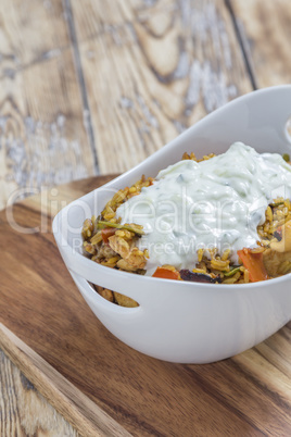 Bowl with curry flavored rice chicken and vegetables