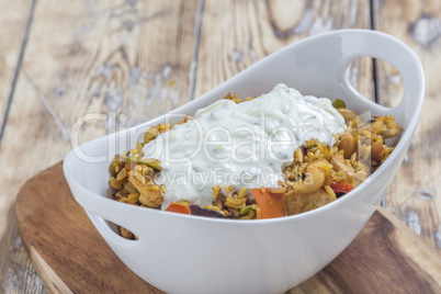 Bowl with curry flavored rice chicken and vegetables