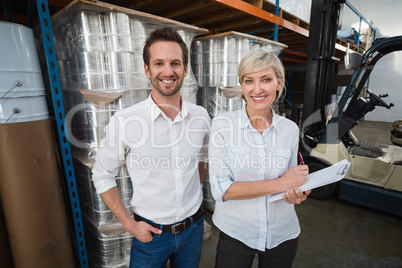 Smiling warehouse managers looking at camera