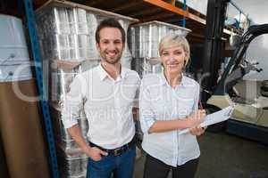 Smiling warehouse managers looking at camera