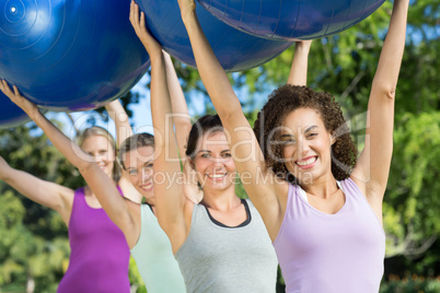 Fitness group holding exercise balls