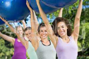 Fitness group holding exercise balls