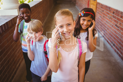 School kids using cellphones in school corridor