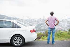 Man looking at the view near his car