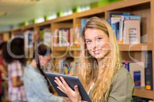 Student using digital tablet in library