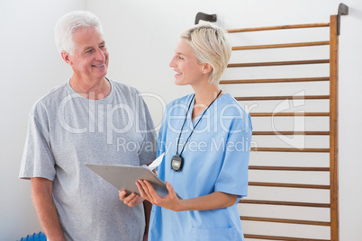 Therapist showing clipboard to senior man