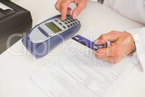 Pharmacist using keypad and holding credit card