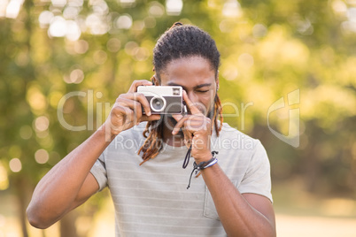 Handsome hipster using vintage camera