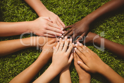 Children keeping hands together over grass