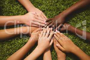 Children keeping hands together over grass
