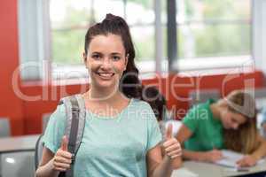 Female student gesturing thumbs up in classroom