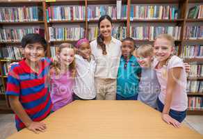 Cute pupils smiling at camera in library