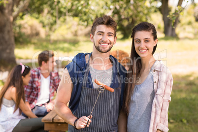 Happy friends in the park having barbecue