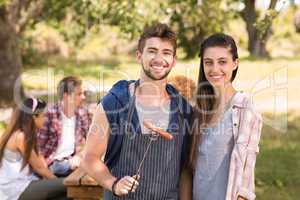 Happy friends in the park having barbecue