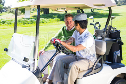 Golfing friends driving in their golf buggy