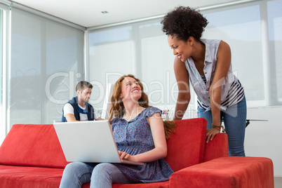 Creative team using laptop on sofa