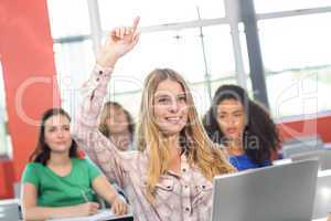 Female student raising hand in classroom