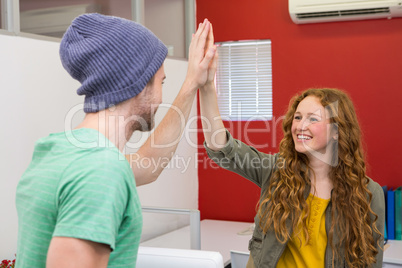Casual businessman and woman high fiving