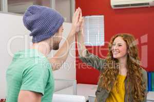 Casual businessman and woman high fiving