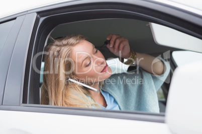 Young woman putting on makeup while calling