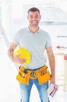 Confident handyman standing at construction site