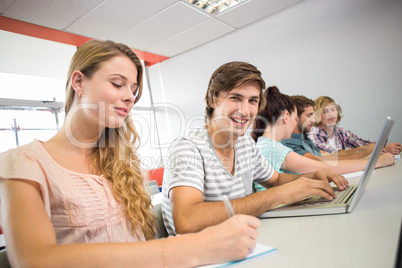 Students writing notes in classroom