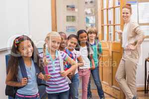 Cute pupils smiling at camera in classroom