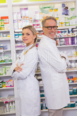 Pharmacist with his trainee standing with arms crossed