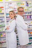 Pharmacist with his trainee standing with arms crossed