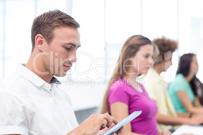 Male student using digital tablet in computer class