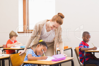 Teacher helping pupil in classroom